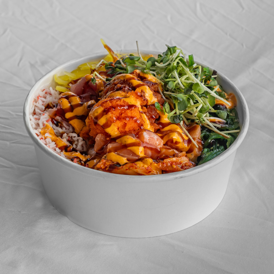 KOKOROLL Poke & Ramen's colorful poke bowl with rice, fish, roe, and greens, drizzled with sauce.