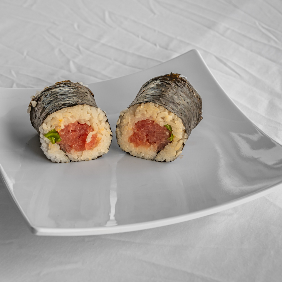 Two KOKOROLL poke rolls with tuna and rice, wrapped in nori, on a white plate.