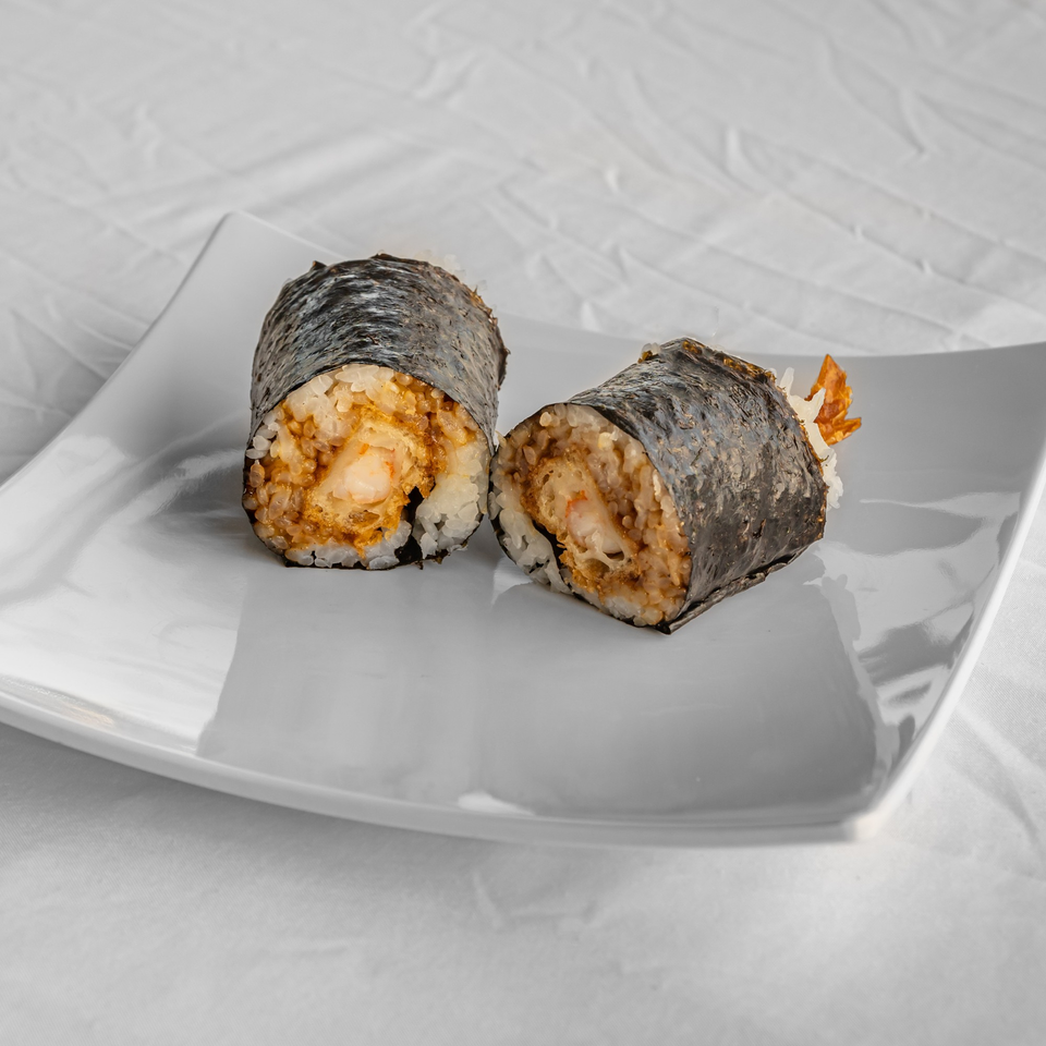 Two KOKOROLL sushi rolls, filled with rice and shrimp tempura, on a white plate.